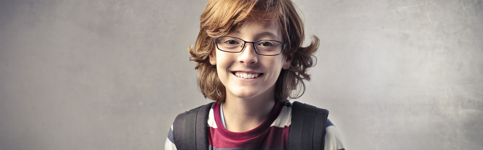 Young man with long hair wearing nice glasses and a backpack